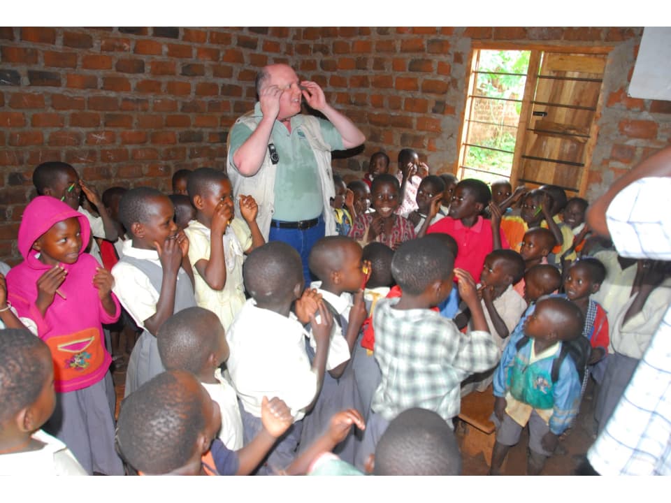 CEMA Ministry international missionary working with rural Ugandan primary school students in class room.